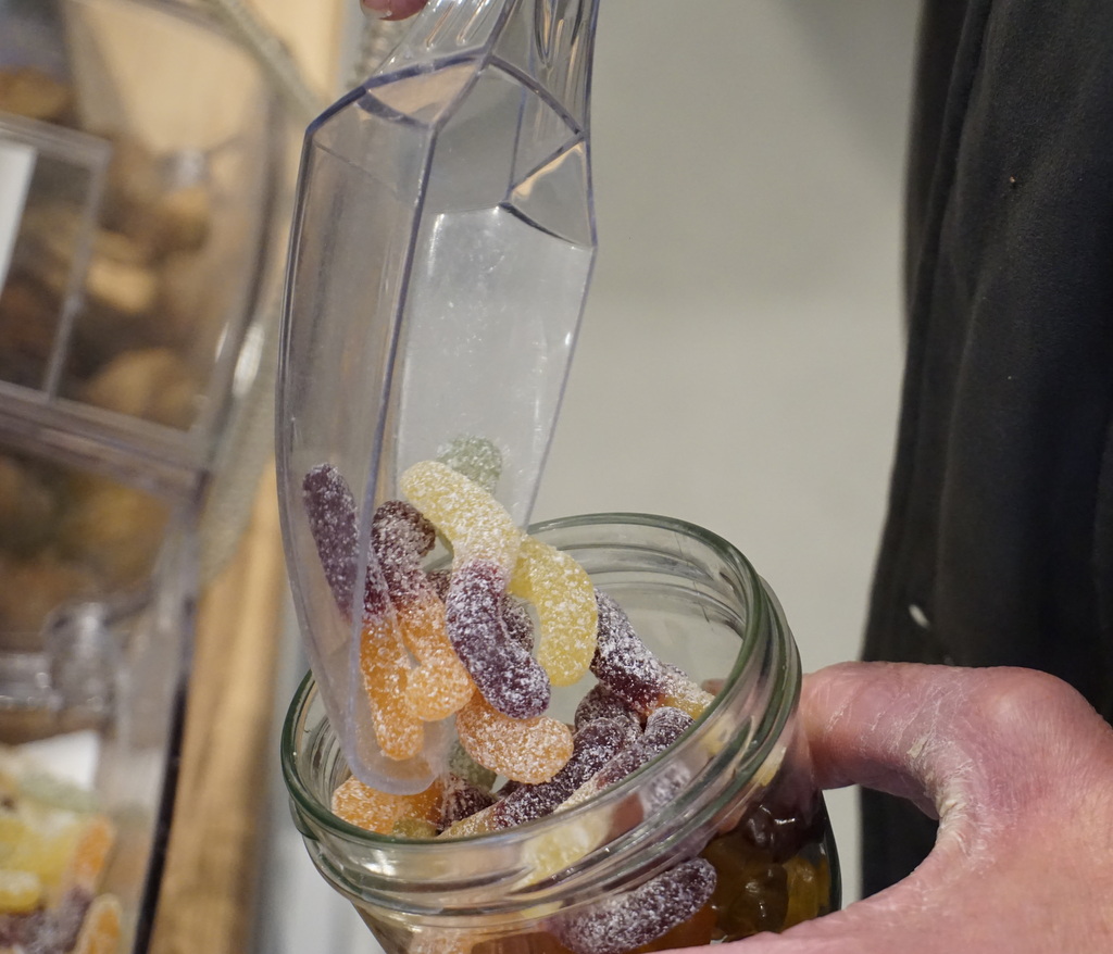 Willi füllt ein Glas mit Gummiwürmern