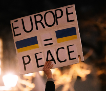 Ein Mensch hält ein Schild mit den Worten Europa und Frieden in die Luft. Er ist auf einer Friedensdemonstration in Heidelberg.