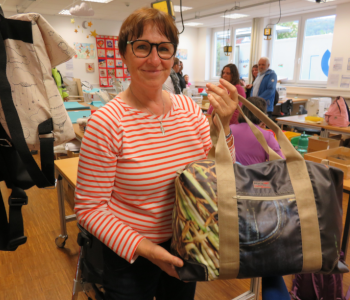 Auf dem Foto ist Gruppenleiterin Karin Fehringer. Sie hält eine selbstgenähte Tasche in der Hand.