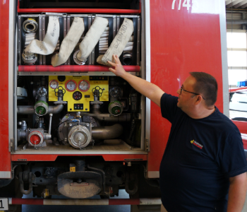 Michael Fanous ist der Chef der Feuerwehr in Kirchheim. Er erklärt ein Feuerwehrauto.