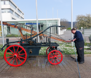 Das Foto zeigt einen alten Wagen mit Wasserpumpe.