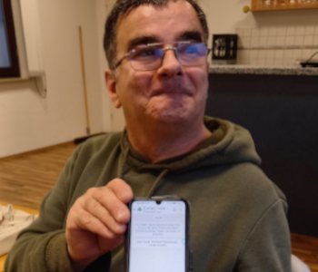 Ein Mann zeigt ein Handy.